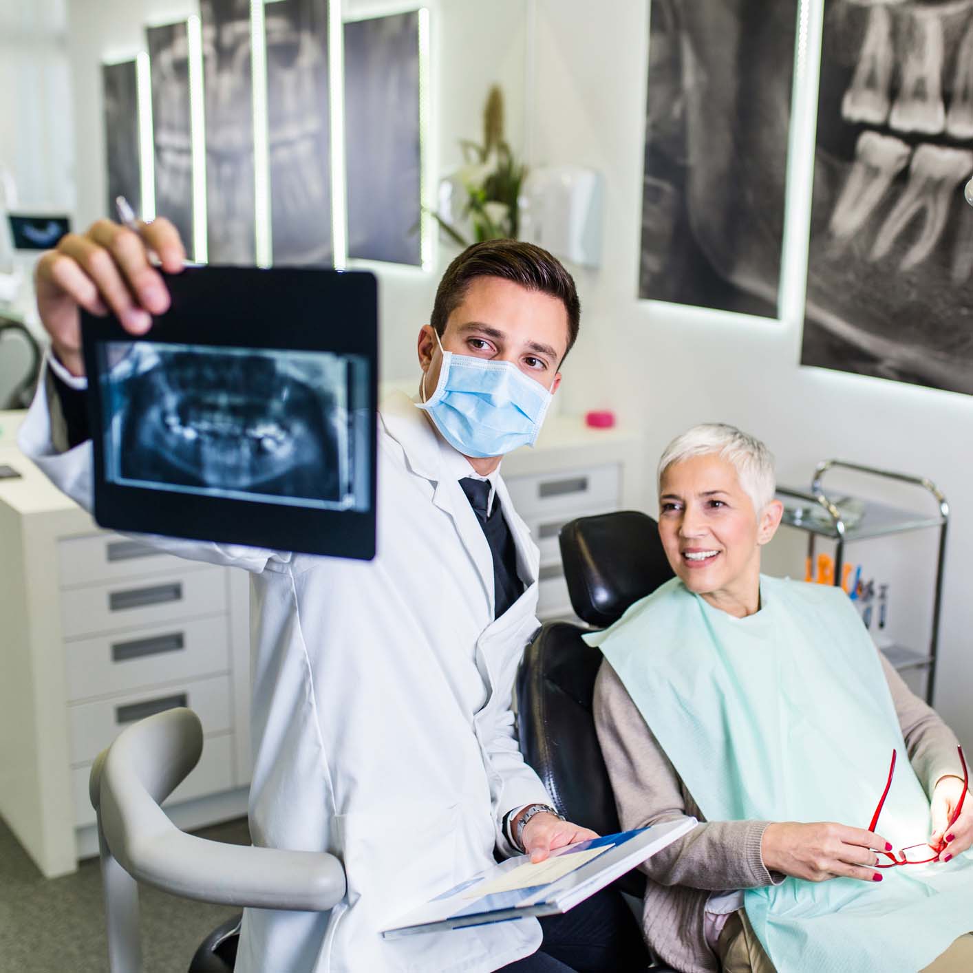 dentist with a patient looking at her X-rays